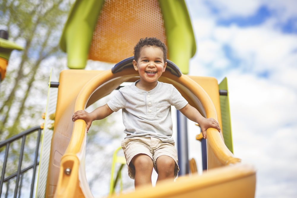 Happy child playing at the Million Smiles Playground, one of the best things to do in Lynden, WA with kids.